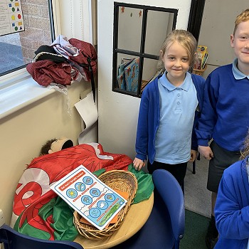 students standing next to a table with the welsh flag on