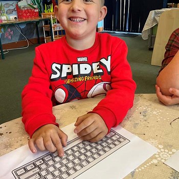A child smiling when taking part in digital club