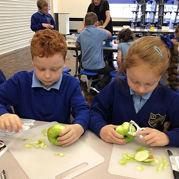 Plant yn pilio afalau ar y bwrdd